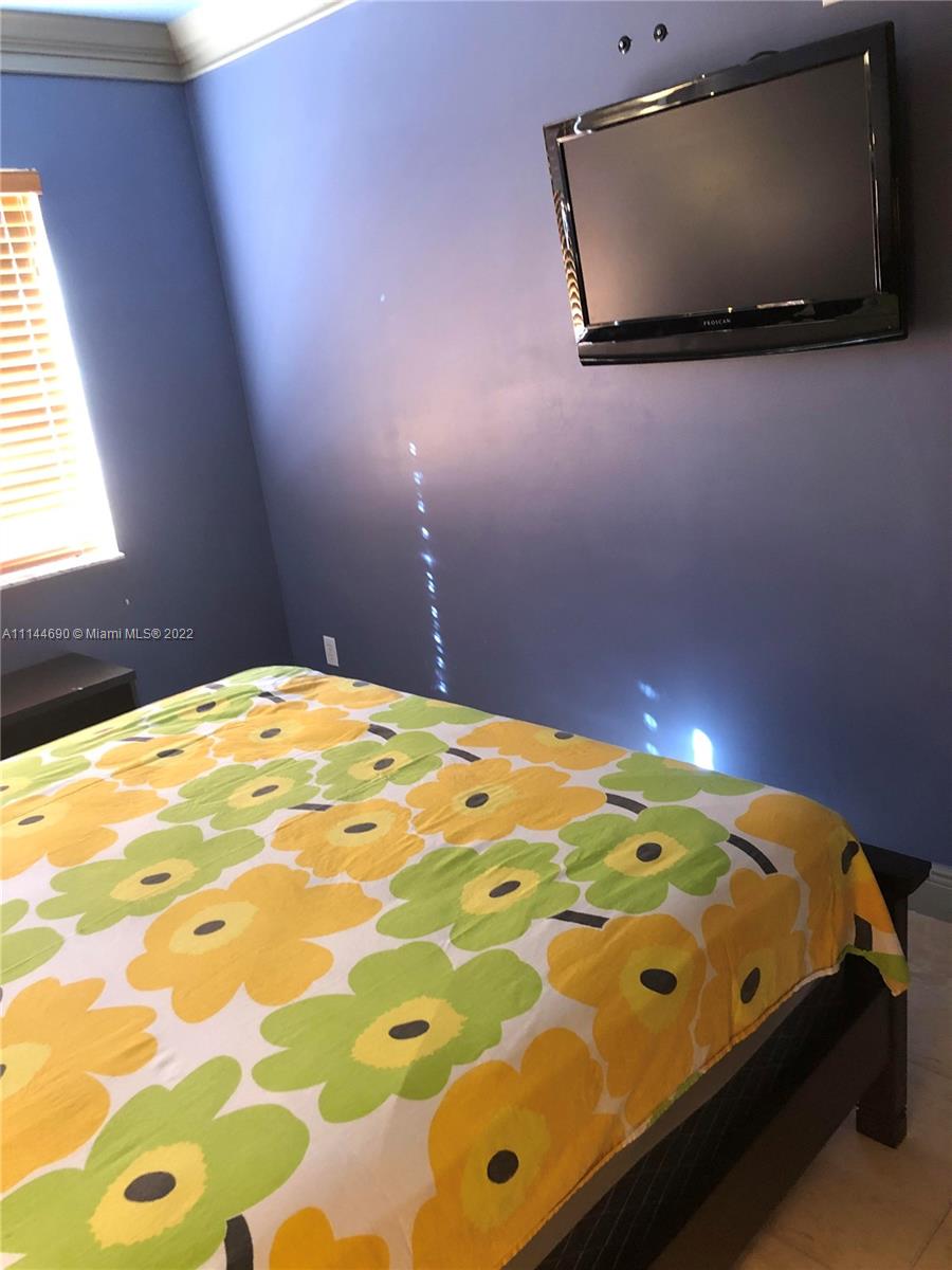 Monarch Lakes Miramar, FL 33027 - Photo 28 of 31 a bedroom with a bed and a flat screen tv