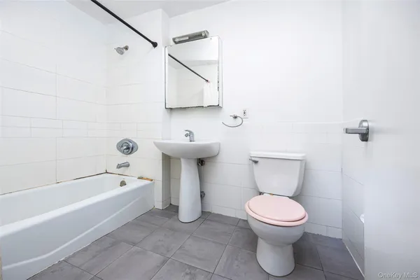a white toilet sitting next to a bath tub