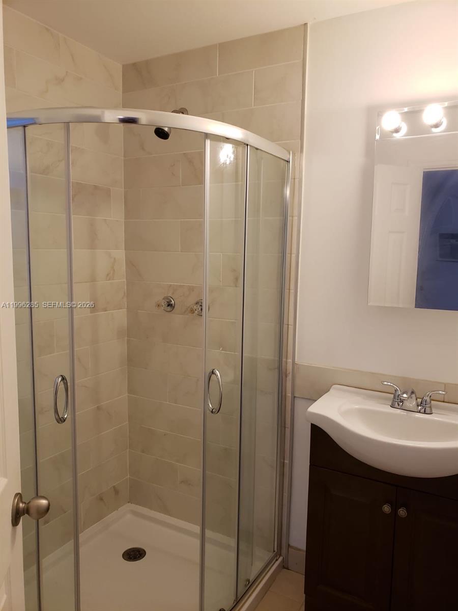 2481 Southwest 11th Street, Unit A Miami, FL 33135 - Photo 3 of 7 a bathroom with a sink a mirror and shower