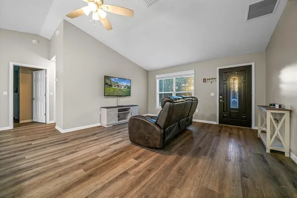 a living room with furniture and a wooden floor