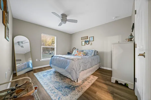 a bedroom with a bed wooden floor and window