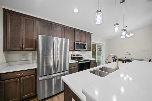 a kitchen with stainless steel appliances kitchen island a refrigerator sink and cabinets