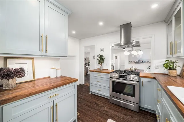 a kitchen with stainless steel appliances a stove and white cabinets