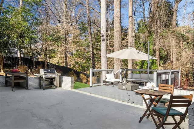 a patio with table and chairs and potted plants