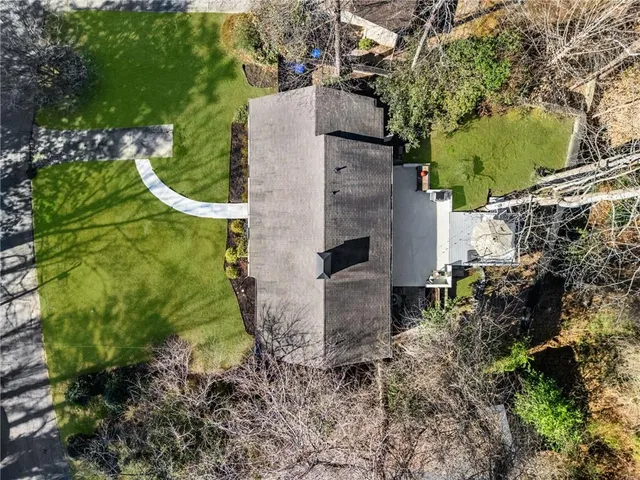 an aerial view of residential house with outdoor space and trees all around
