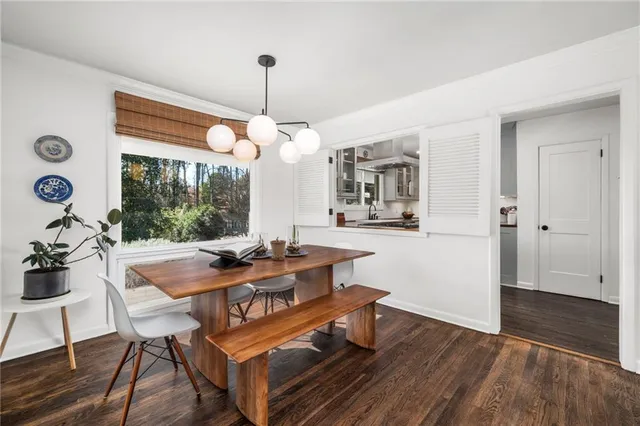 a view of a dining room and livingroom with furniture wooden floor a chandelier