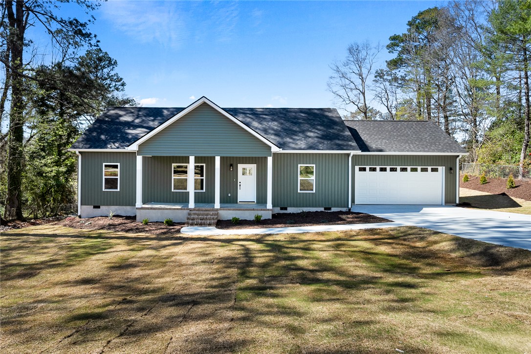 This newly constructed home boasts a charming covered front porch and an attached garage.