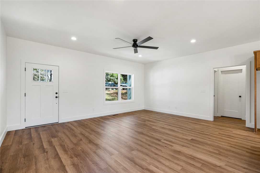 125 Cambridge Lane Pendleton, SC 29670 - Photo 4 of 22 This airy living space features rich wood flooring, a window offering natural light, and a clean, modern aesthetic.