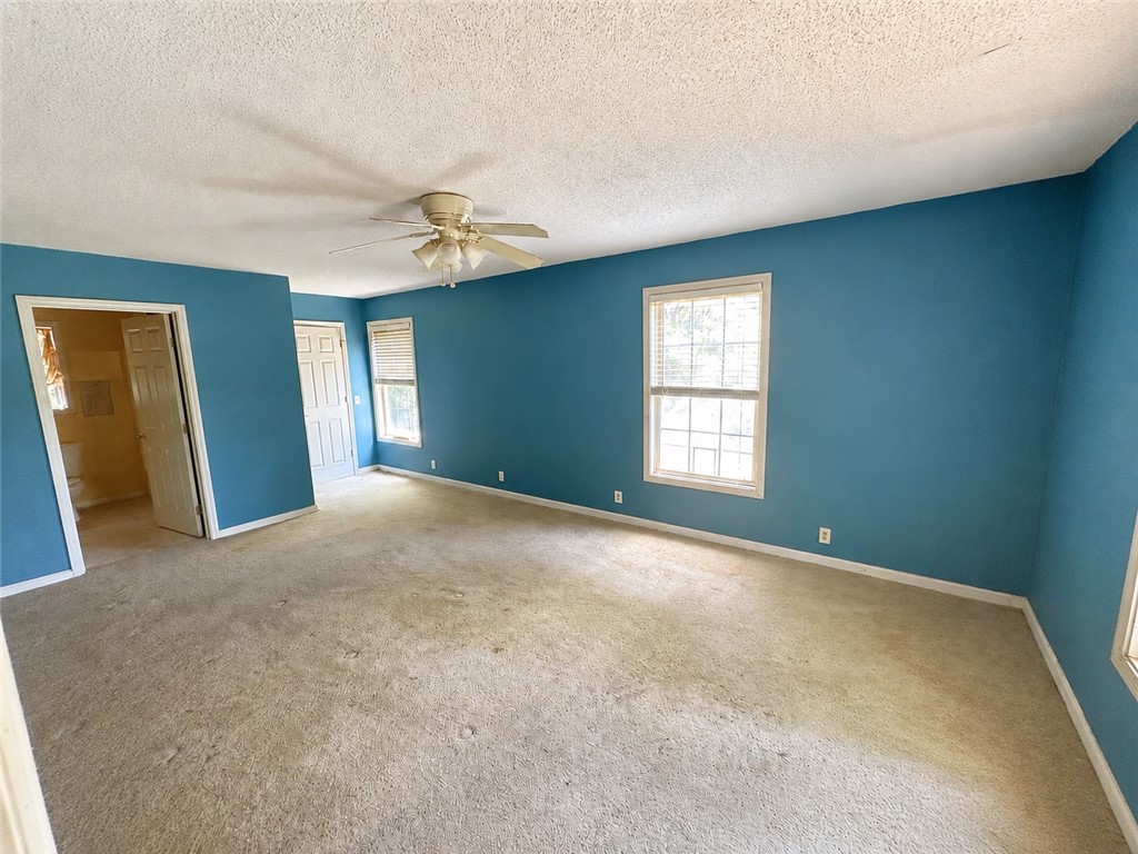 138 Cloverdale Road Seneca, SC 29678 - Photo 18 of 27 A spacious primary bedroom with vibrant walls and natural light, featuring a convenient attached private bathroom.