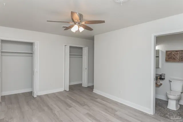 a view of a room with wooden floor and a ceiling fan