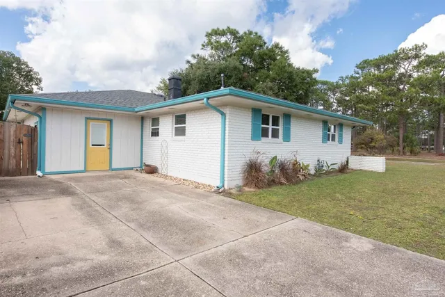 a view of a house with a yard and potted plants