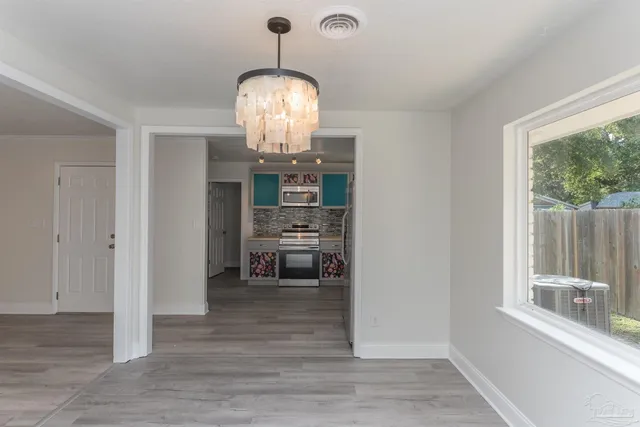 a view of a room with wooden floor fireplace and windows