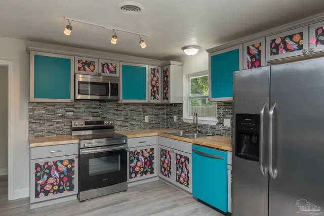 a kitchen with stainless steel appliances granite countertop a refrigerator and a sink