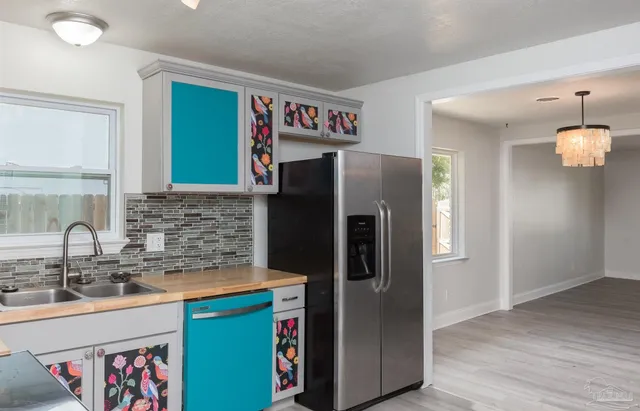a kitchen with stainless steel appliances granite countertop a refrigerator and a sink