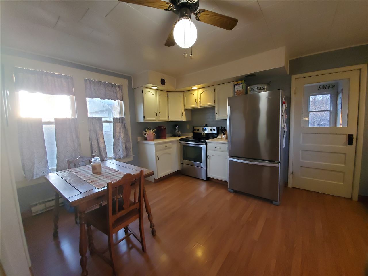 14375 West Springdale Road Forreston, IL 61030 - Photo 22 of 39 a kitchen with stainless steel appliances wooden floor dining table and chairs