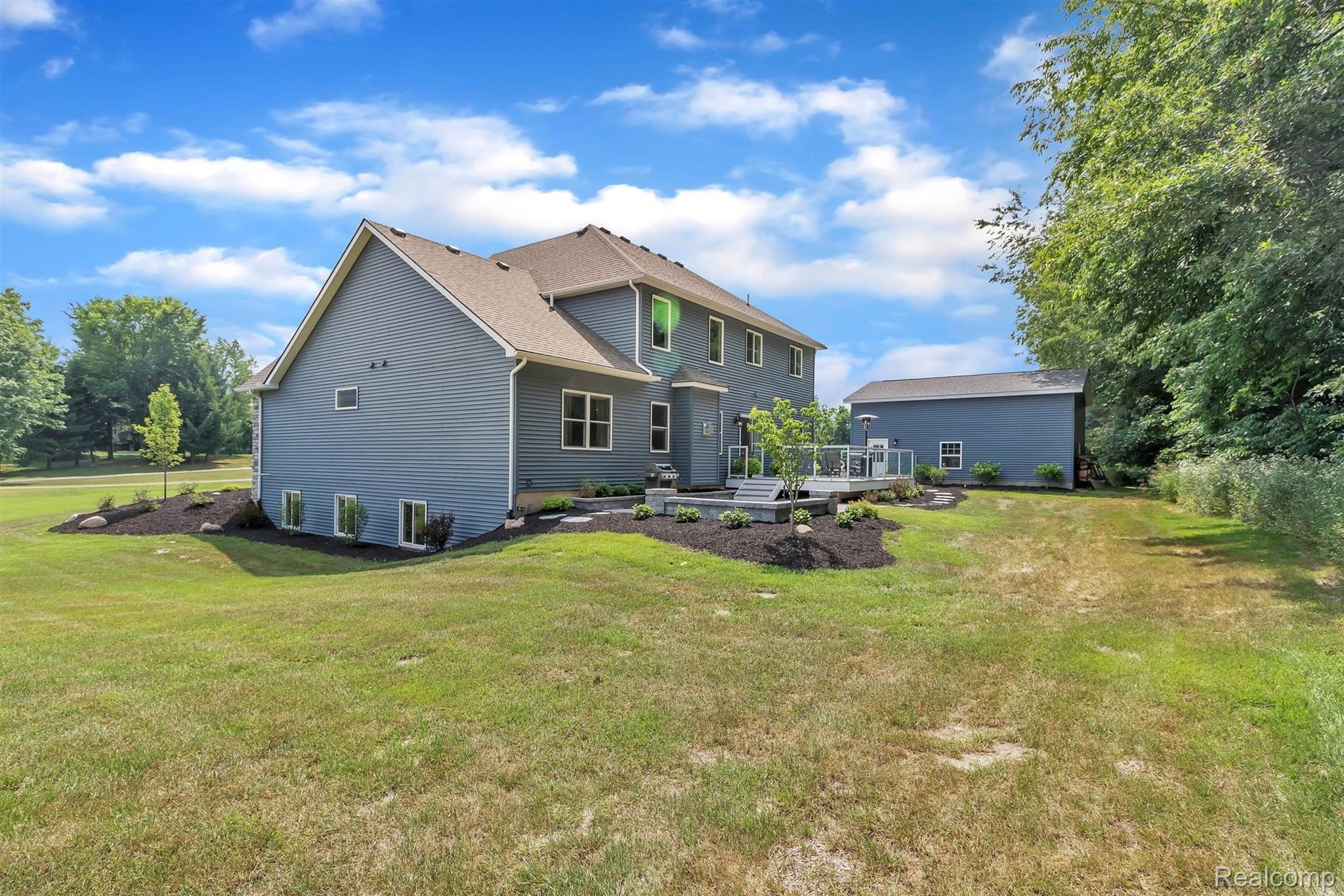 860 North Hacker Road Howell, MI 48843 - Photo 34 of 53 Rear of Home with Barn, Professional Landscaping, Trek Deck