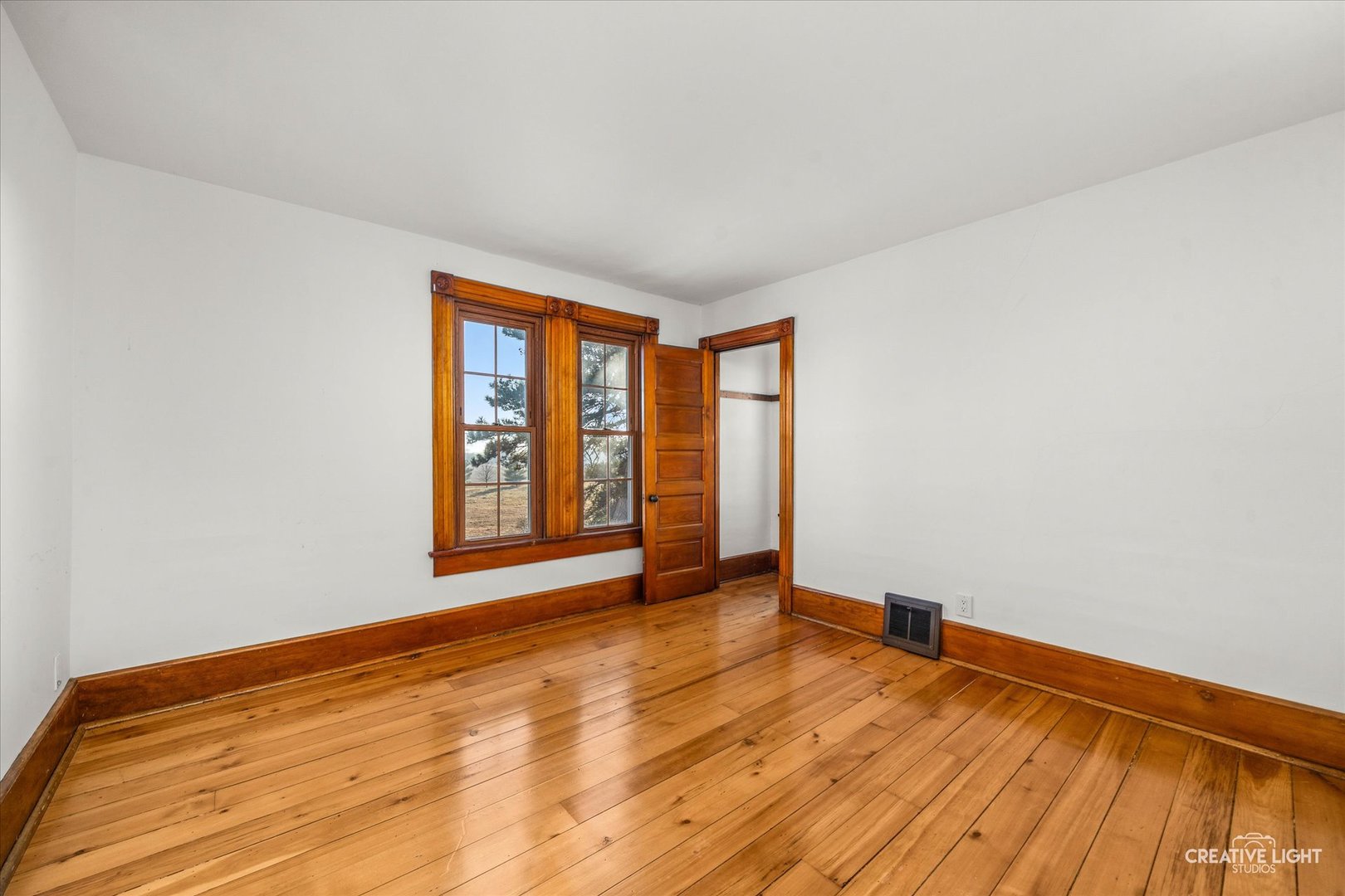 10256 Somonauk Road Hinckley, IL 60520 - Photo 18 of 44 a view of an empty room with wooden floor and a window