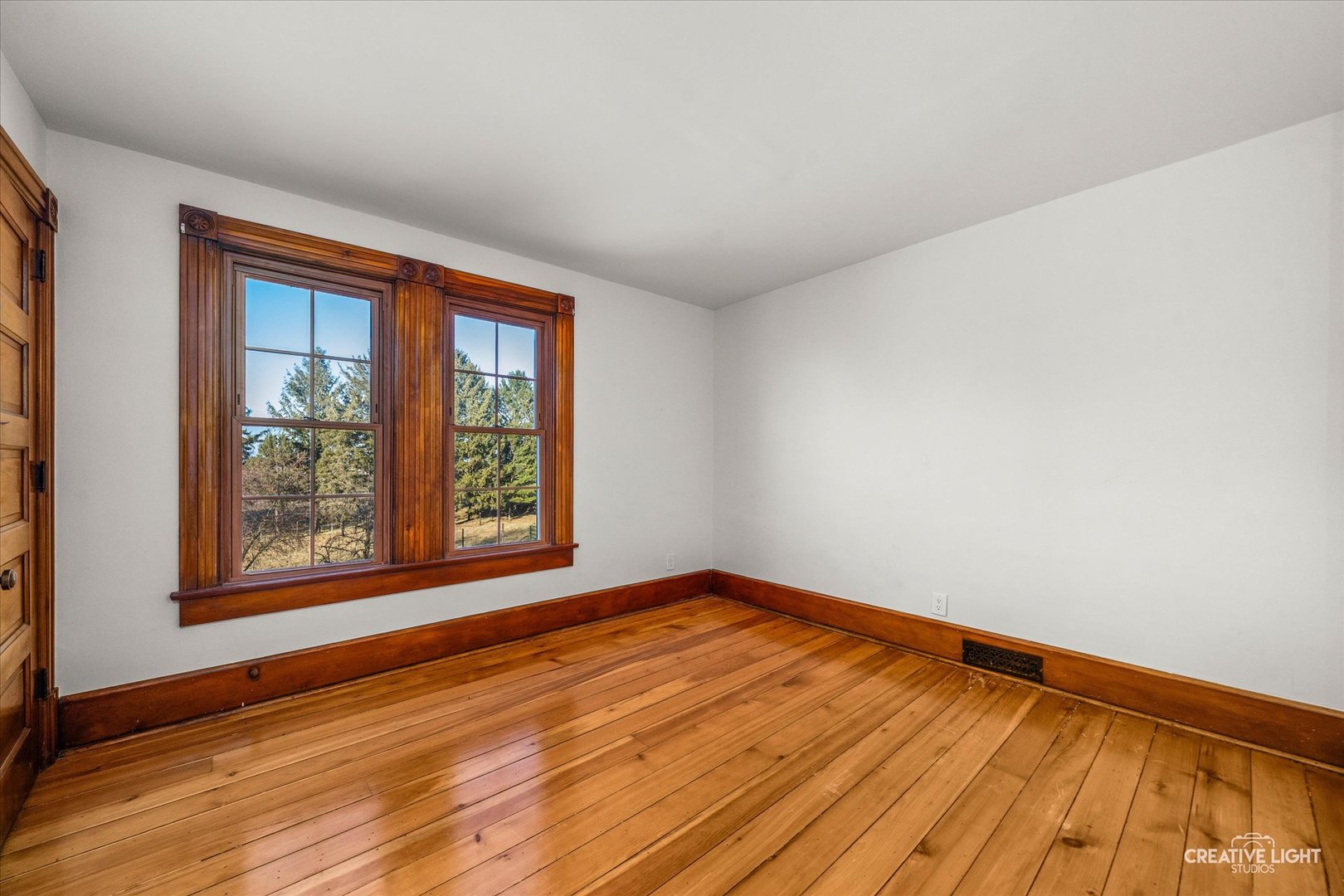 10256 Somonauk Road Hinckley, IL 60520 - Photo 19 of 44 a view of an empty room with wooden floor and a window