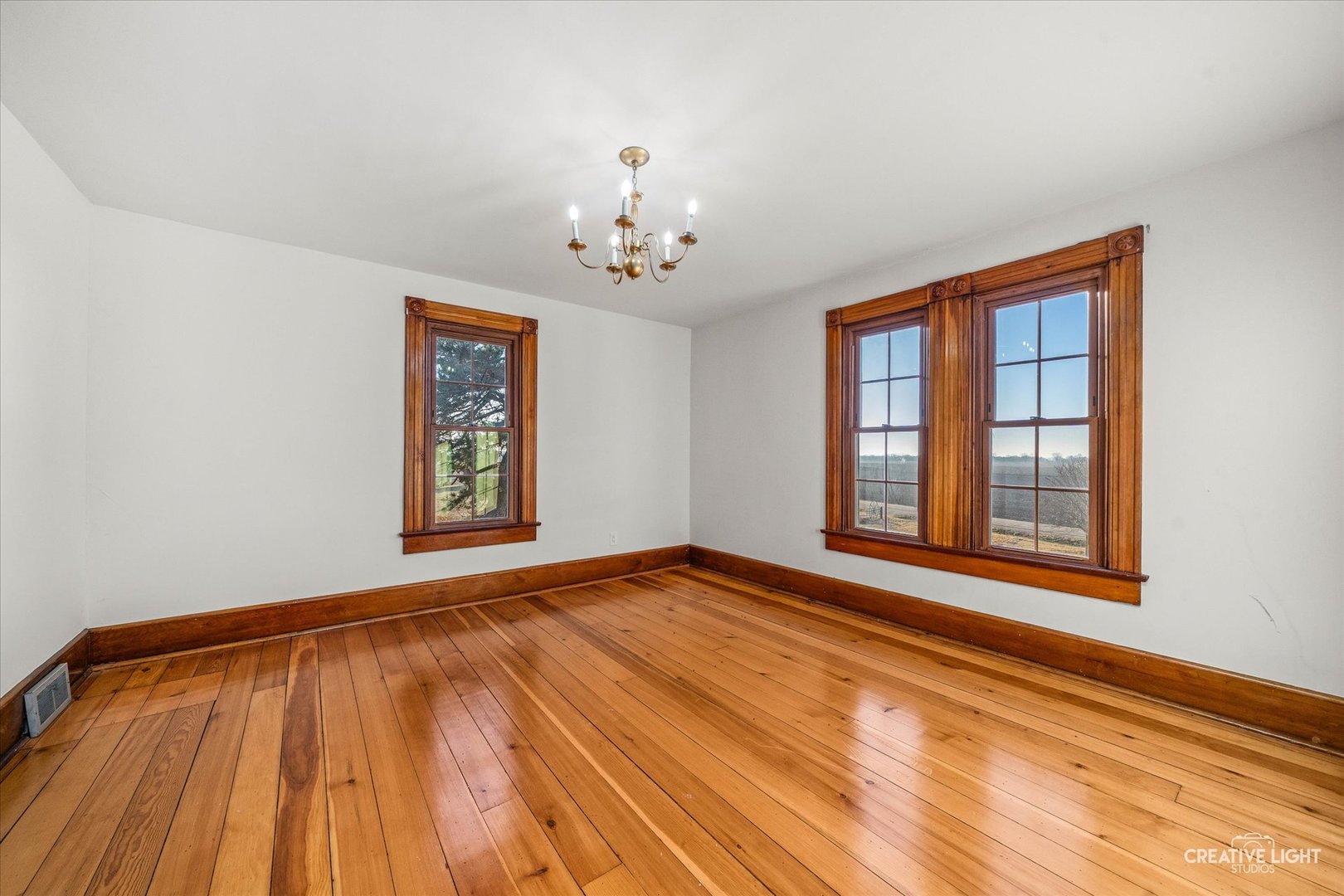 10256 Somonauk Road Hinckley, IL 60520 - Photo 20 of 44 a view of an empty room with a window and wooden floor