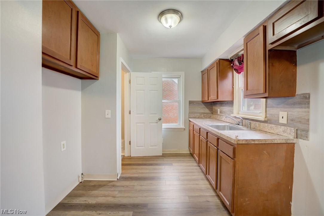 6106 Dunham Road Maple Heights, OH 44137 - Photo 11 of 23 Kitchen with light hardwood / wood-style flooring, sink, and backsplash