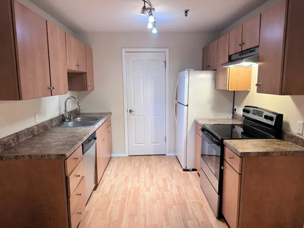 a kitchen with a sink stove and refrigerator