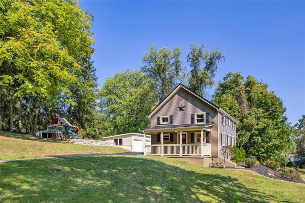 a front view of a house with a yard and trees