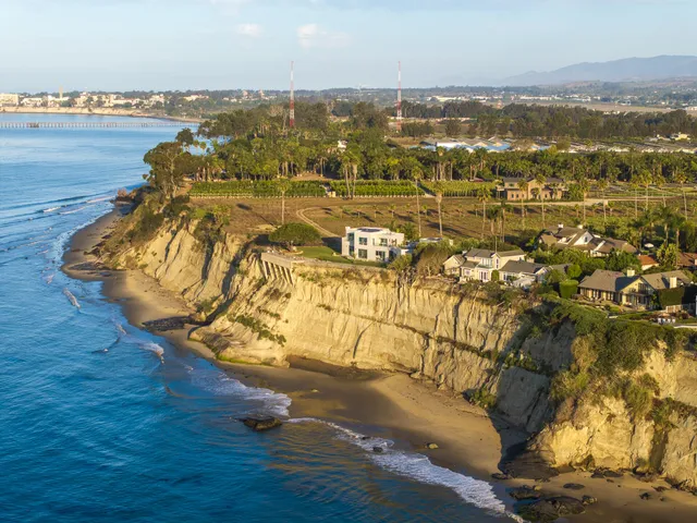 an aerial view of residential houses with outdoor space and trees