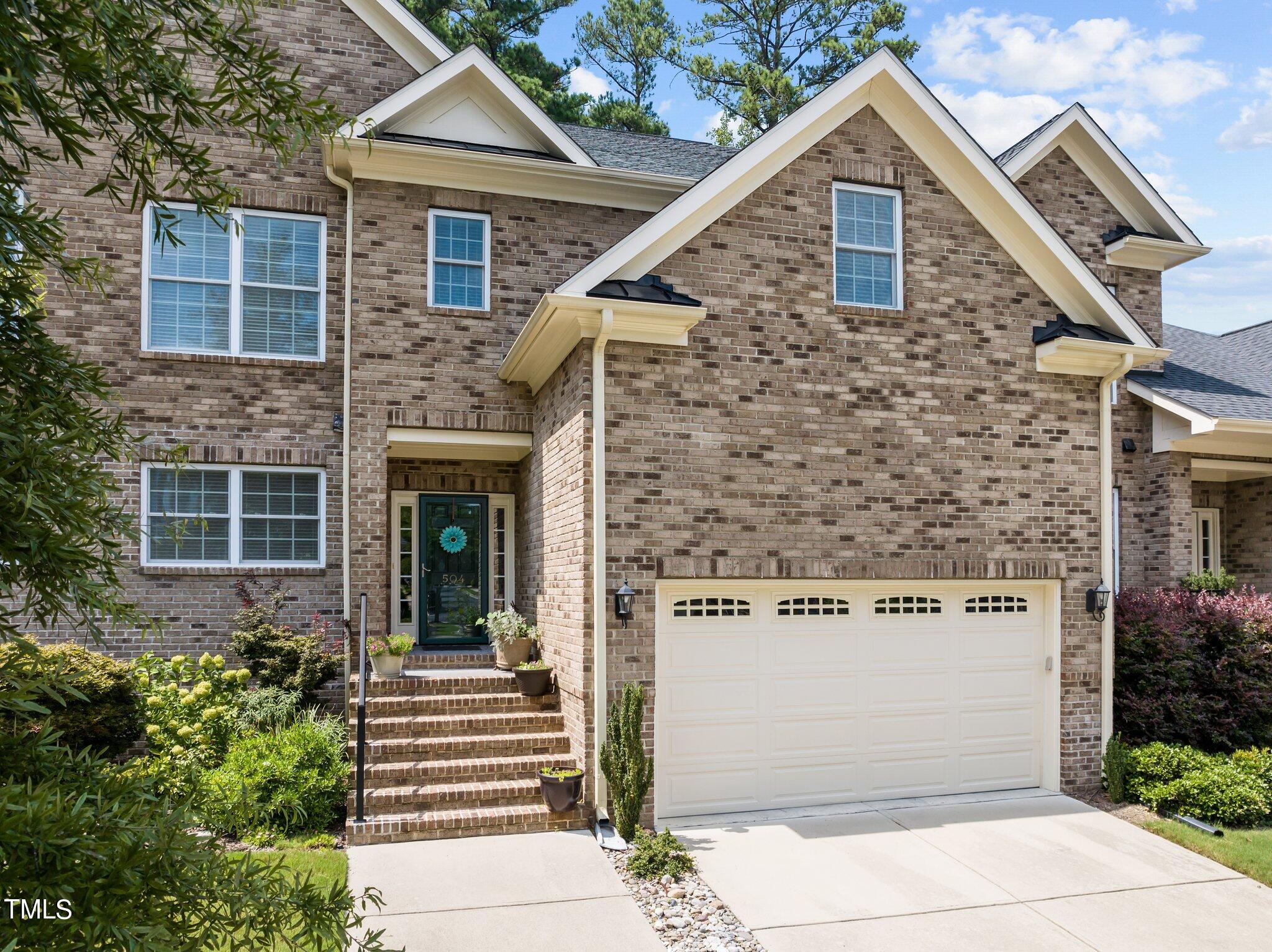 a front view of a house with plants