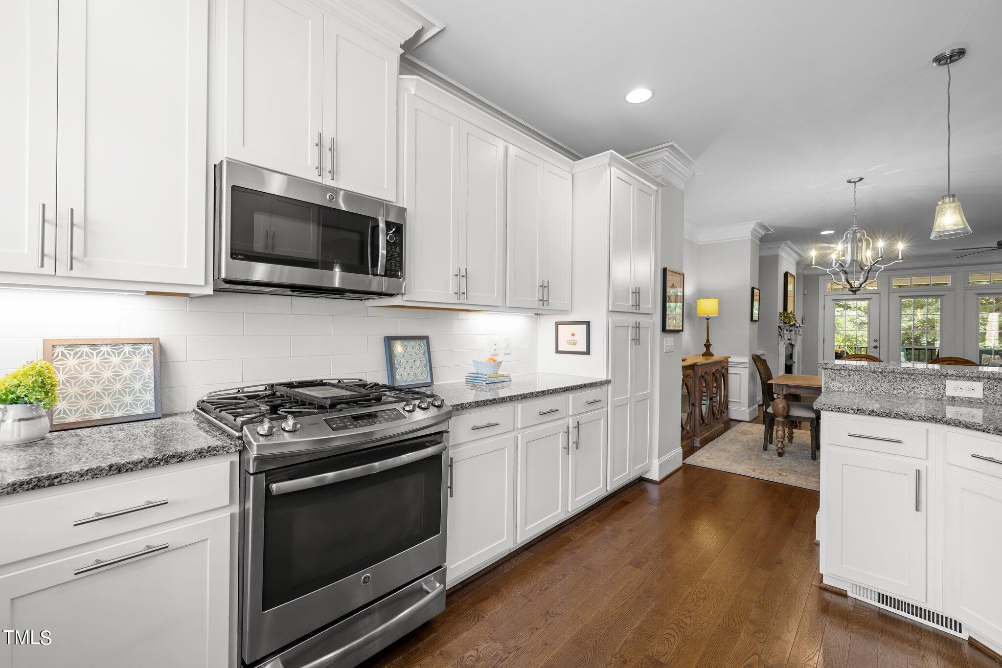 504 Valleyshire Road Durham, NC 27707 - Photo 10 of 38 a kitchen with stainless steel appliances granite countertop a stove top oven a sink dishwasher and white cabinets with wooden floor