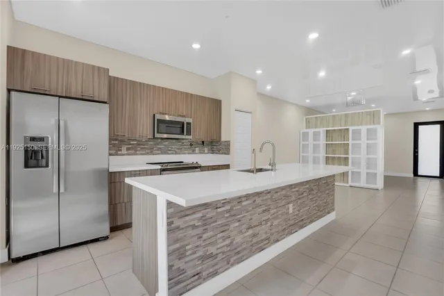 a large kitchen with stainless steel appliances granite countertop a large counter top and a stove top oven