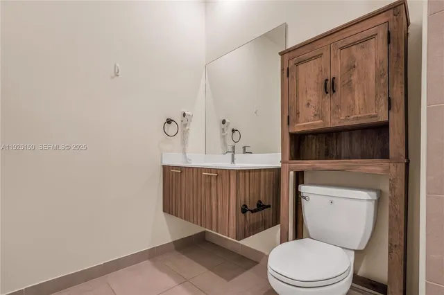 a bathroom with a toilet a sink and mirror
