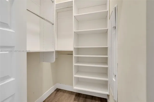 a view of walk in closet with empty racks