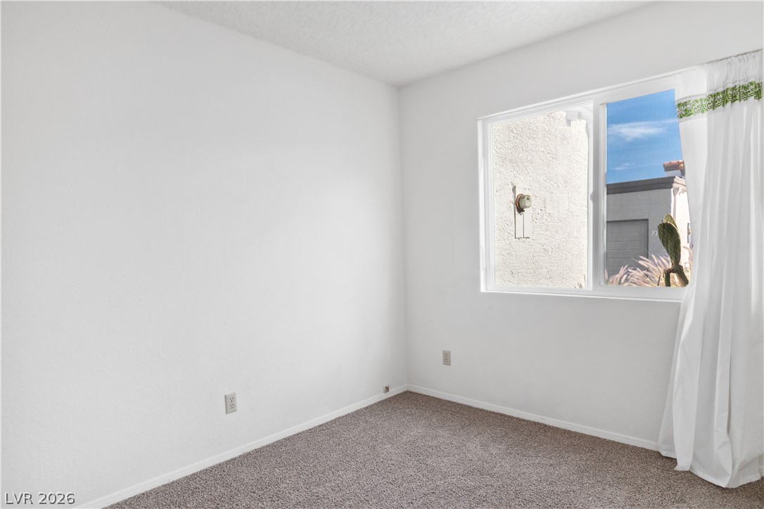 2146 High Dunes Lane Laughlin, NV 89029 - Photo 32 of 64 Second bedroom featuring a textured ceiling, a healthy amount of sunlight, baseboards, and carpet