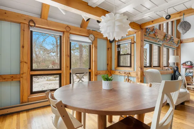 a view of a dining room with furniture a chandelier and wooden floor