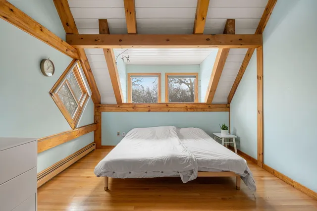 a bedroom with a bed and wooden floor