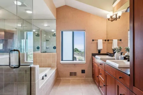 a bathroom with double vanity and a bathtub