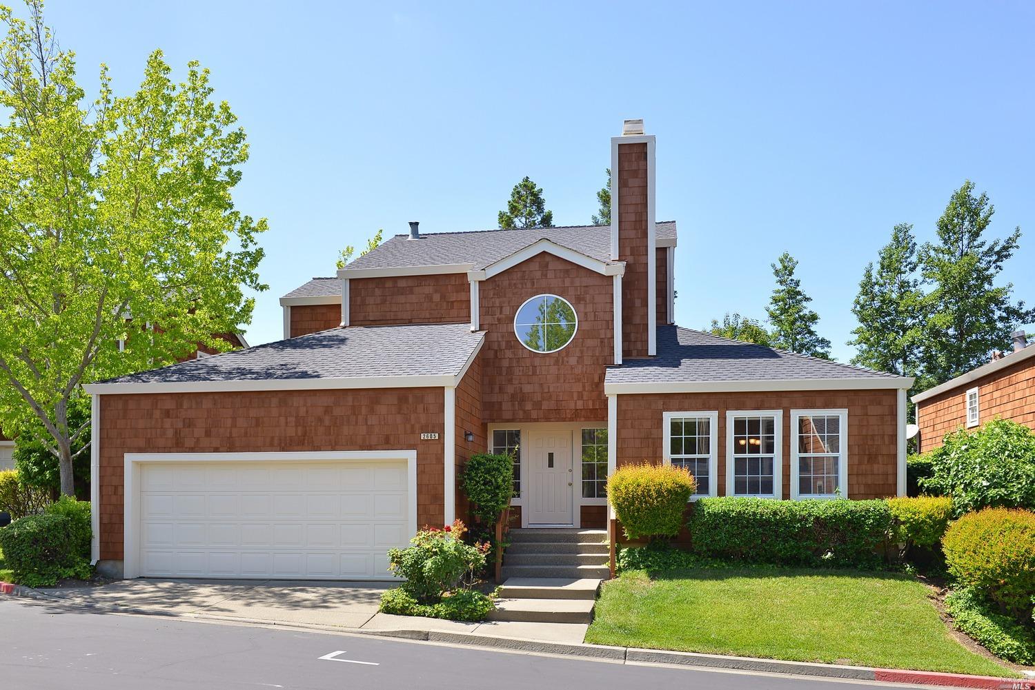 a front view of a house with garden and garage