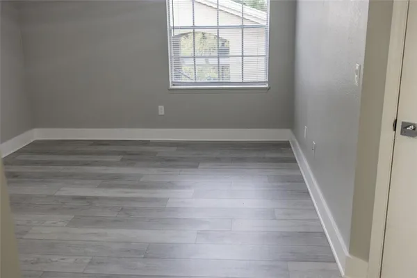 a view of a room with wooden floor and window