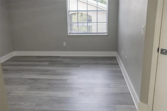 a view of a room with wooden floor and window