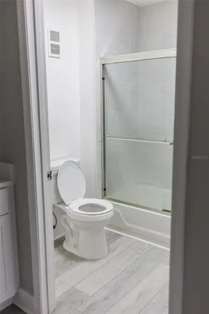 a bathroom with a toilet and a glass shower door