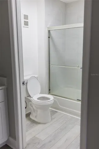 a bathroom with a toilet and a glass shower door