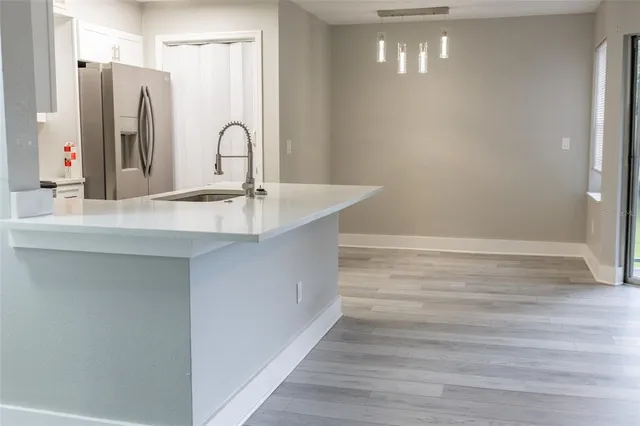 a close view of a sink a counter space and a refrigerator