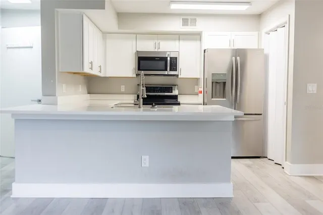 a kitchen with stainless steel appliances a refrigerator and a stove