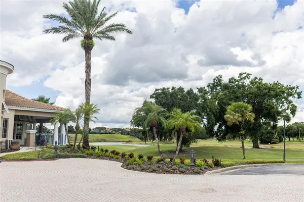 a front view of multi story residential apartment building with yard and green space