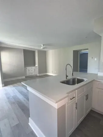 a view with a sink and cabinet with granite countertops