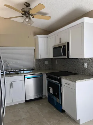 a kitchen with stainless steel appliances granite countertop a stove and a microwave