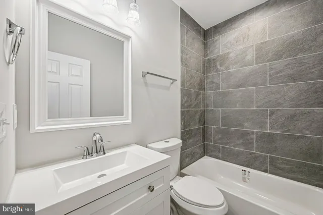 an empty room with wooden floor and fan