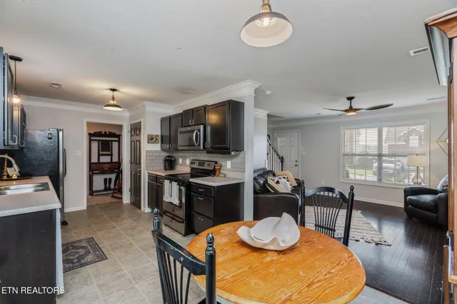 a kitchen with stainless steel appliances granite countertop a stove a sink a dining table and chairs