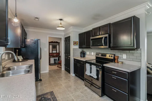 a kitchen with stainless steel appliances wooden cabinets a stove and a sink