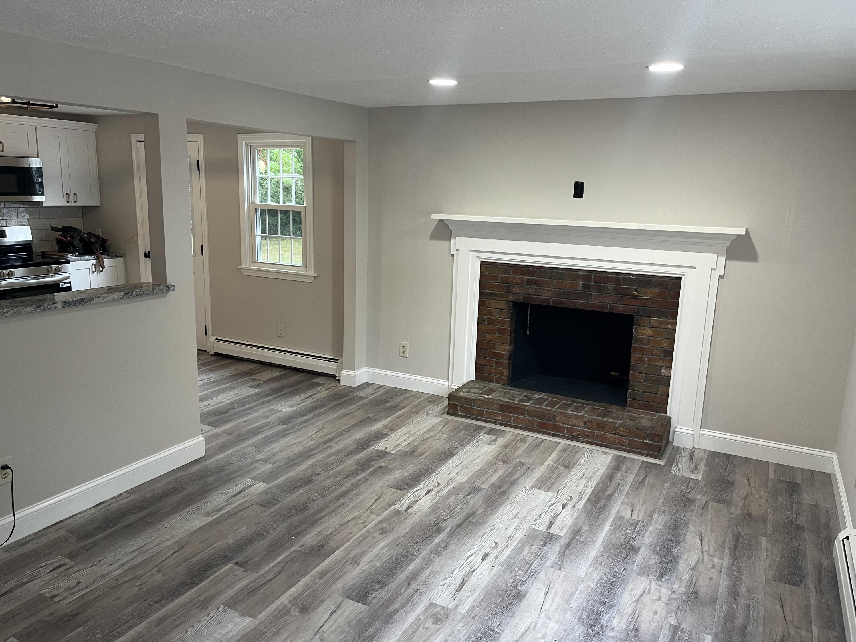 49 Burnham Street Barnstable, MA 02648 - Photo 16 of 17 an empty room with wooden floor a fireplace and windows
